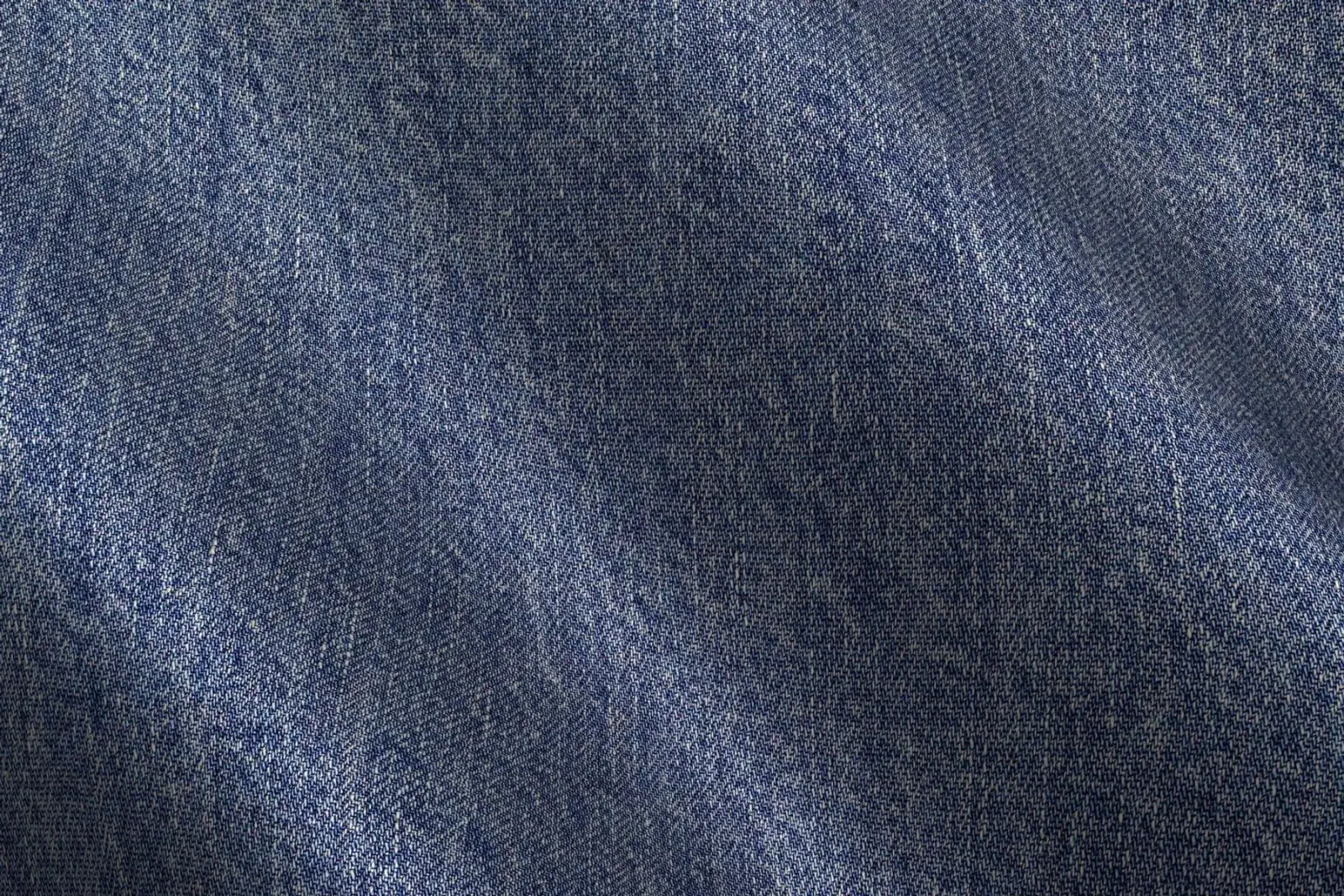 Cận cảnh mặt vải denim xanh, thấy rõ độ mịn và thớ sợi