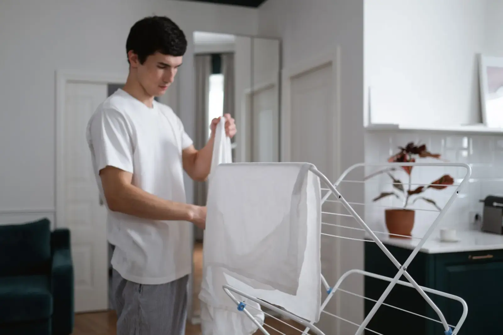 Người đàn ông phơi quần áo trắng lên giá phơi trong nhà