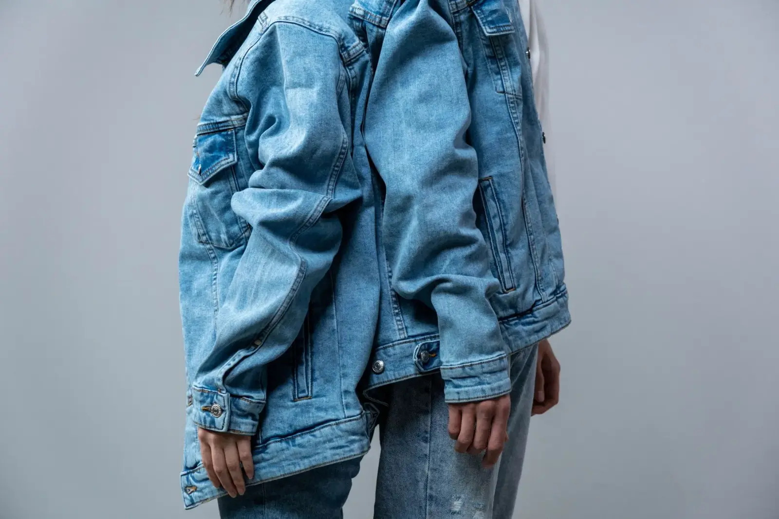 Bộ đồ denim gồm áo khoác jean phối quần jean, chụp trong studio