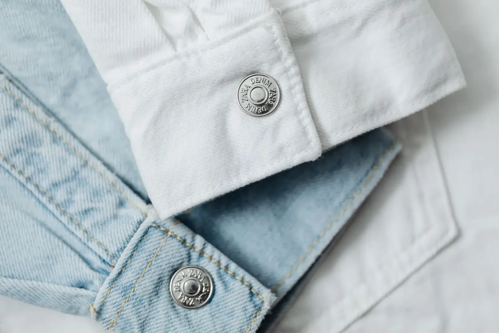 Cận cảnh quần denim trắng và xanh nhạt xếp cạnh nhau