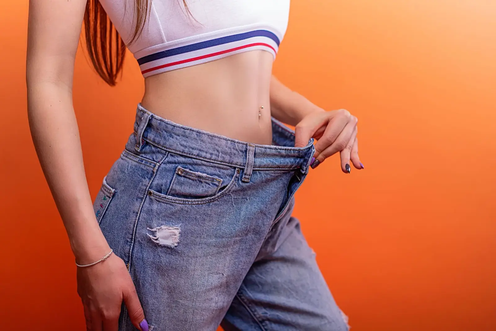 Người phụ nữ kéo chiếc quần jean rộng ra khỏi vòng eo