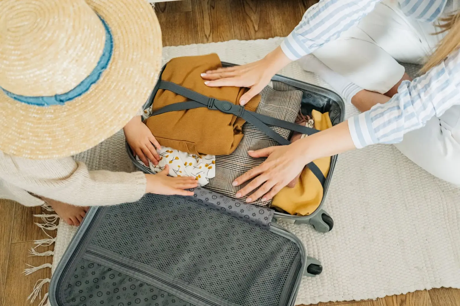Hai mẹ con xếp quần áo vào vali chuẩn bị đi xa