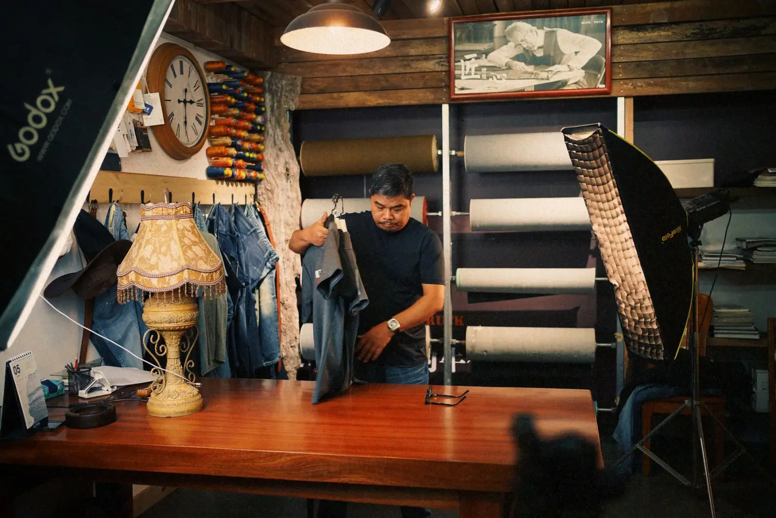 Người thợ may nam sắp xếp vải denim trong xưởng