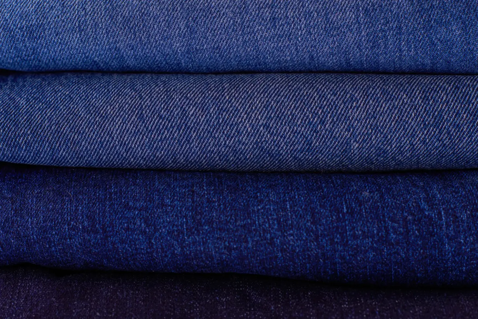 Nhiều lớp vải denim gấp gọn xếp chồng, mỗi lớp một sắc độ