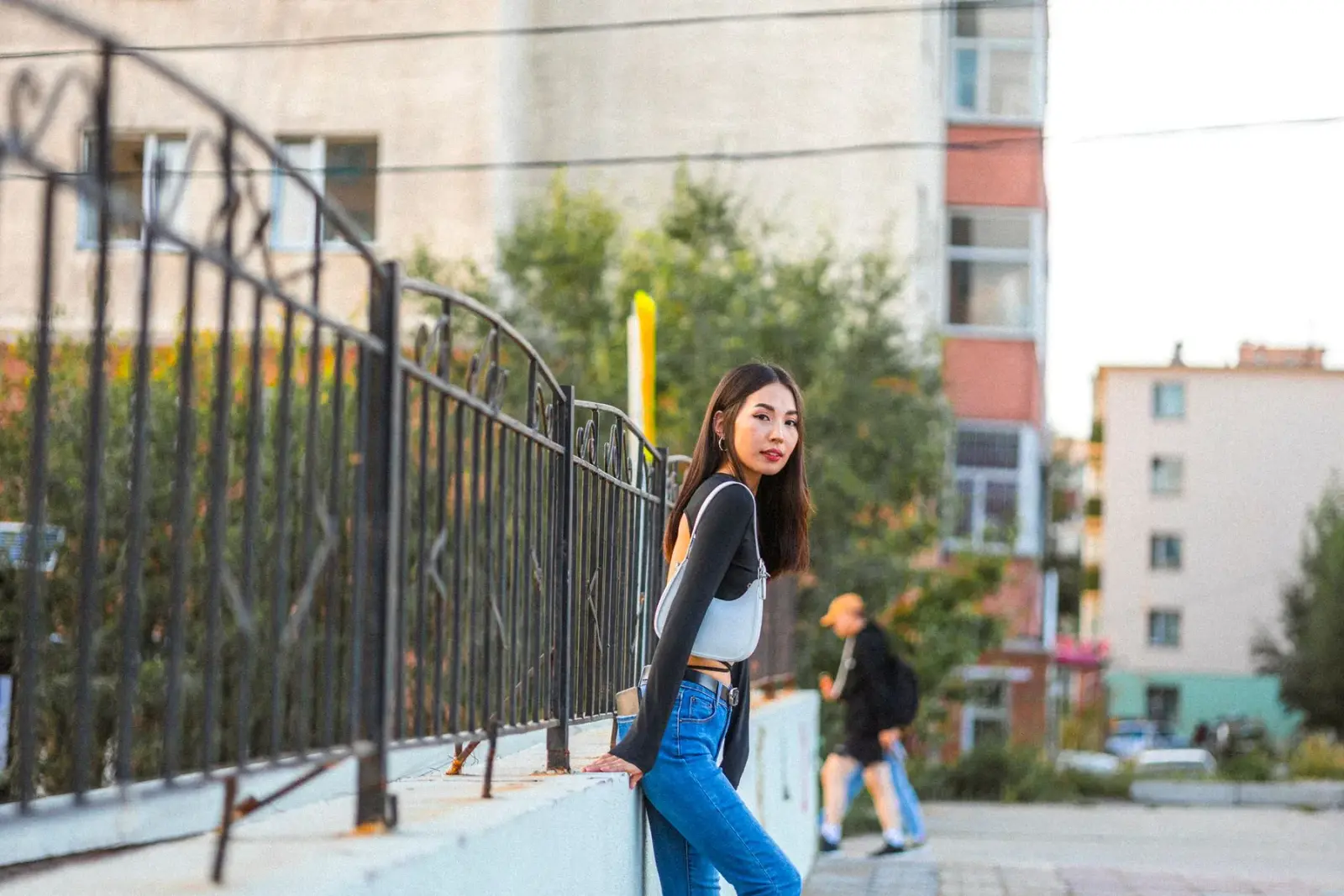 Người phụ nữ tựa vào hàng rào, mặc đồ thường ngày