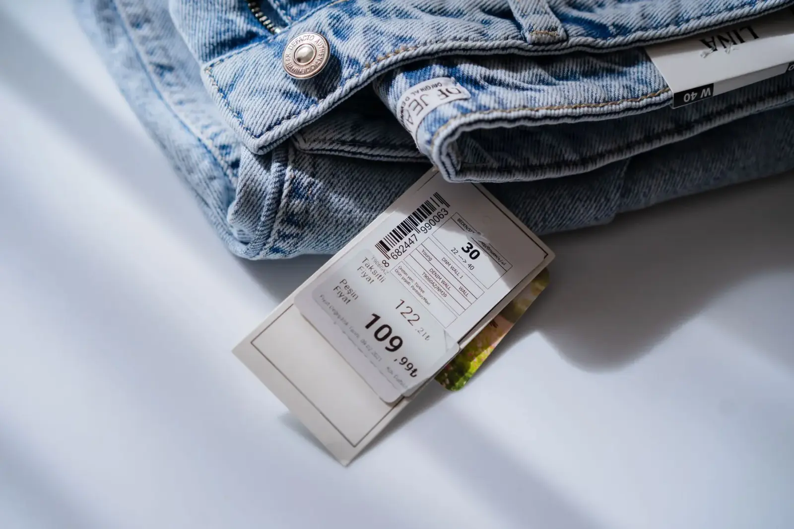 Chiếc quần jean với tem giá và tem size, chụp từ trên