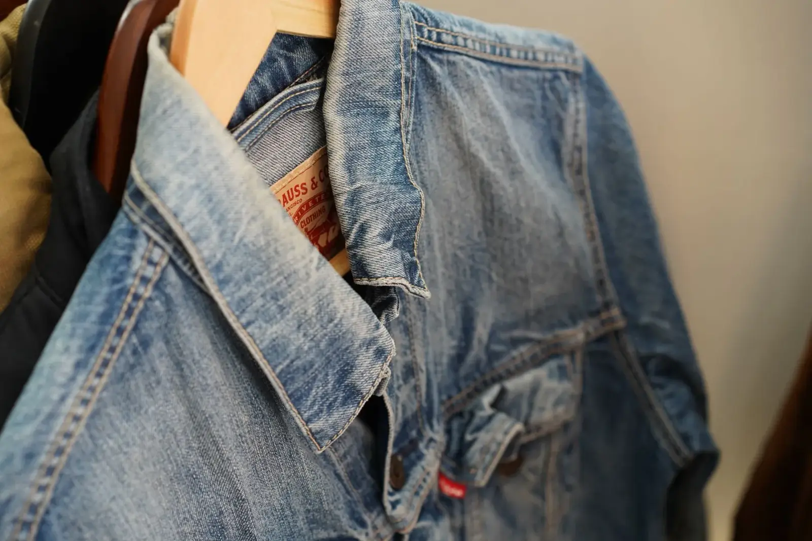 Áo khoác denim xanh treo trên móc gỗ