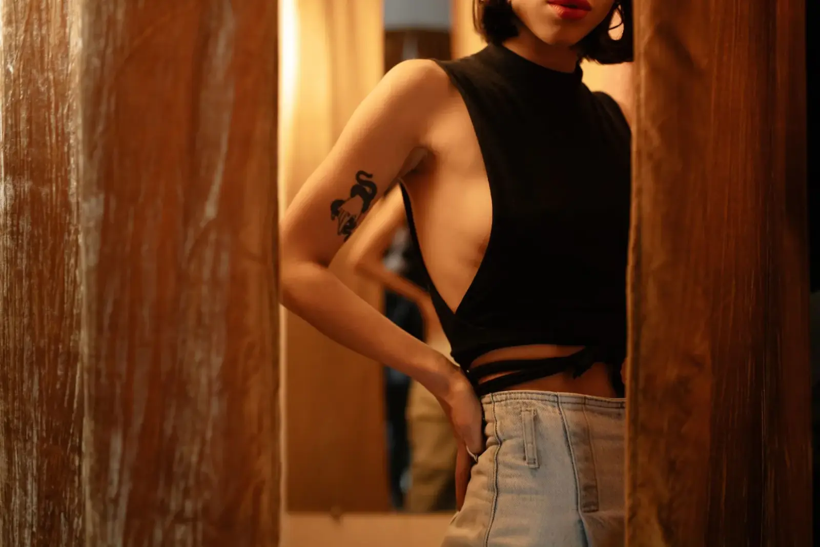 Người mặc áo croptop và quần denim đứng tạo dáng