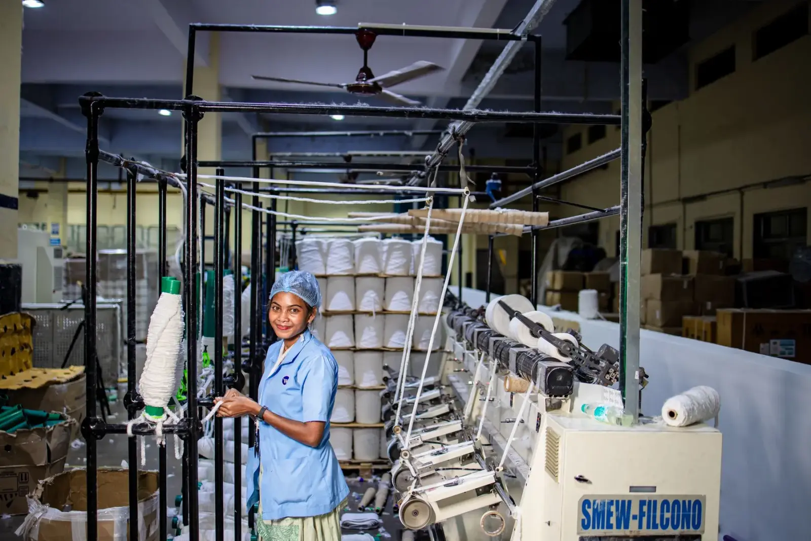 Nữ công nhân vận hành máy trong xưởng kéo sợi